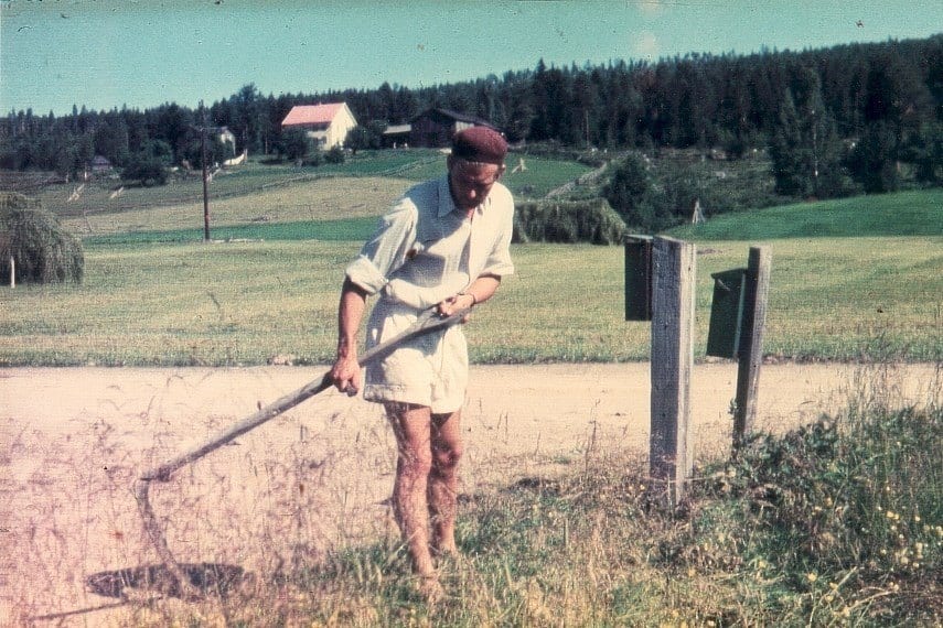Åke slår vägrenen med lie.