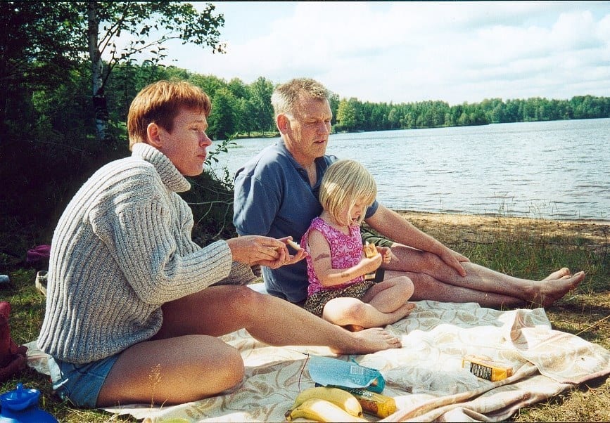 Jonas och Lisbet sitter på en filt vid sjön med sin dotter.